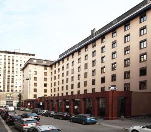 un grande edificio con auto parcheggiate in un parcheggio di Starhotels Ritz a Milano