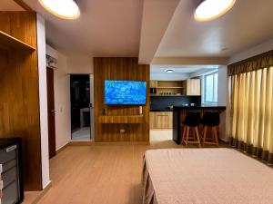 a living room with a tv and a kitchen at Matrix Alojamiento in Punta Negra