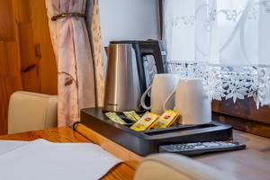 a coffee maker on a table with two candles at Dworek Galicyjski in Oświęcim +56 photos