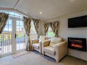 a living room with two chairs and a fireplace at The Orchard - Uk7111 in Alloa