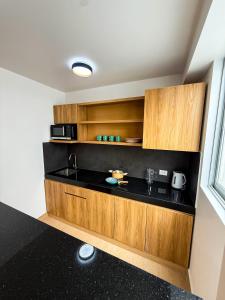 a kitchen with wooden cabinets and a sink at Matrix Alojamiento in Punta Negra +22 photos