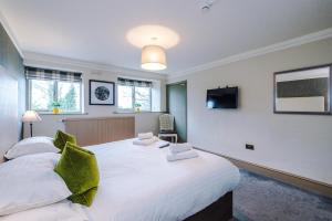 a bedroom with two beds and a flat screen tv at Slyne Lodge in Hest Bank