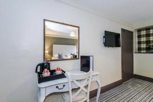 a hotel room with a desk and a mirror at Slyne Lodge in Hest Bank
