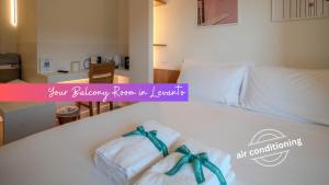 a couple of towels sitting on a bed at Isabella Boutique Rooms in Levanto