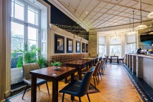 a restaurant with wooden tables and chairs and windows at Slyne Lodge in Hest Bank