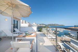a balcony with an umbrella and a table and chairs at Hotel Cala Bona in Cala Bona