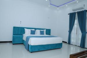 a blue bed in a white room with at Palmyra resort in Jaffna