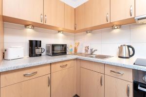 a kitchen with wooden cabinets and a counter top at Haus 1 Matrose in Kellenhusen