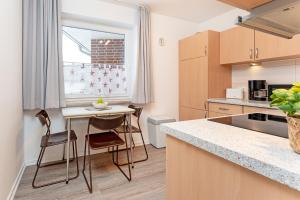 a kitchen with a table and chairs and a window at Haus 1 Matrose in Kellenhusen