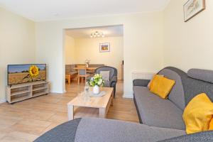 a living room with a couch and a tv at Haus 1 Matrose in Kellenhusen