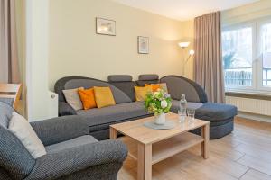 a living room with a couch and a table at Haus 1 Matrose in Kellenhusen