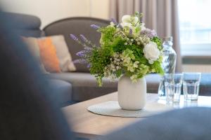 a vase of flowers on a table in a living room at Haus 1 Matrose in Kellenhusen +25 photos