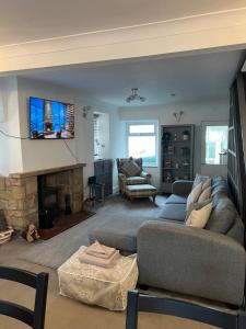 a living room with a couch and a fireplace at Epworth Cottage in Crich
