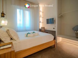 a bedroom with a large white bed with towels on it at Isabella Boutique Rooms in Levanto