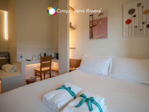 a bedroom with a white bed with towels on it at Isabella Boutique Rooms in Levanto