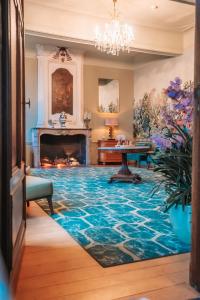 a living room with a fireplace and a blue rug at Château de Looz in Borgloon