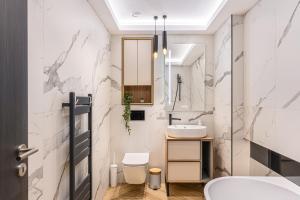 a white bathroom with a sink and a toilet at KOA - Signature Collection in Braşov +92 photos