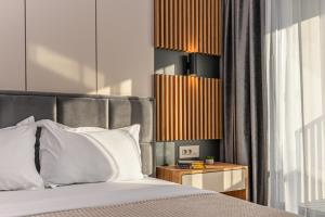 a bedroom with a bed with white pillows at KOA - Signature Collection in Braşov