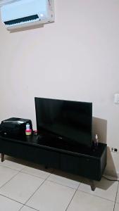 a black entertainment center with a flat screen tv on it at Sonho de verão in Guarulhos