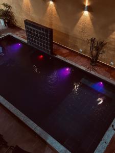 a swimming pool with purple lights on top of it at Sonho de verão in Guarulhos