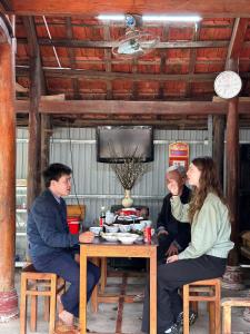 a group of people sitting around a table at Loren Homestay in Phong Nha