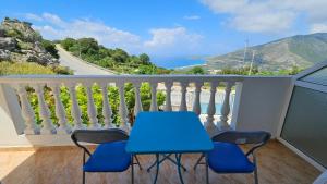 a blue table and chairs on a balcony with a view at Vila Riand in Borsh