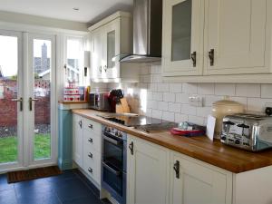 a kitchen with white cabinets and a counter top at Gullsway in Beadnell