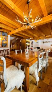 a dining room with a large wooden table and chairs at Heritage Villa Predelut - Fireplace & Baby Crib in Predeluţ