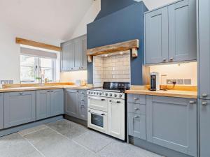 a kitchen with blue cabinets and white appliances at 1 Bed in Taunton oc-80693 in North Curry +9 photos