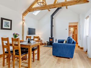 a dining room and living room with a table and a blue couch at 1 Bed in Taunton oc-80693 in North Curry