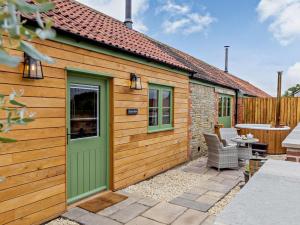 a tiny house with a green door and a patio at 1 Bed in Taunton oc-80693 in North Curry