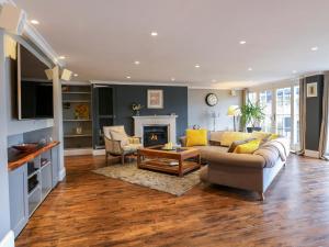 a living room with a couch and a fireplace at River Haven - River Thames frontage house in Thames Ditton