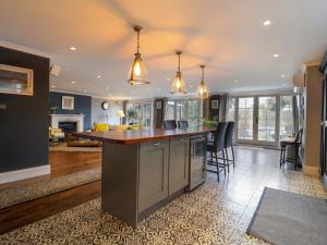 an open kitchen and living room with a large island at River Haven - River Thames frontage house in Thames Ditton