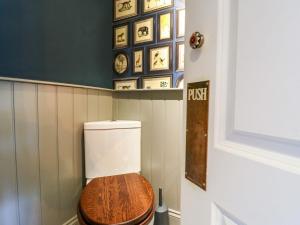 a toilet with a wooden seat in a bathroom at River Haven - River Thames frontage house in Thames Ditton +44 photos