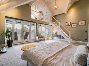 a bedroom with a large bed and a staircase at River Haven - River Thames frontage house in Thames Ditton