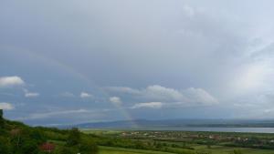 a rainbow in the sky over a field with a city at Casa Wylak Winery in Uileacu de Criş