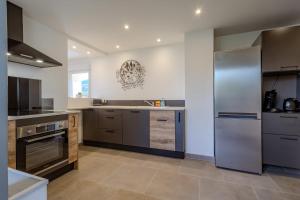 a large kitchen with stainless steel appliances and cabinets at Gîte La perle d’Alsace in Bernardswiller