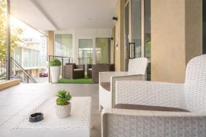 patio z białymi krzesłami i doniczkową rośliną w obiekcie Hotel Adria Mare w Rimini +18 zdjęć