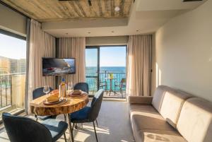 a living room with a couch and a table with chairs at Del Mar Court in Marsalforn