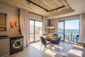 a dining room with a table and a view of the ocean at Del Mar Court in Marsalforn
