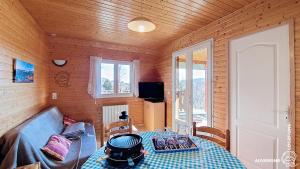 a living room with a table and a couch at Chalet de la Gougère 1 in Chambon-sur-Lac