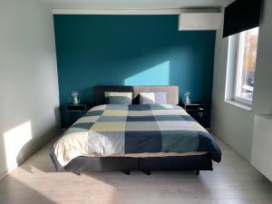 una camera da letto con un letto con una parete blu di JoHa Haus a Hasselt