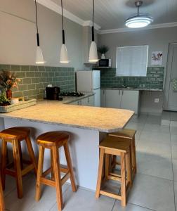 a kitchen with a counter and two stools in it at Joba-Rus in Bloemfontein