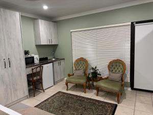 a kitchen with two chairs and a table in a kitchen at Joba-Rus in Bloemfontein