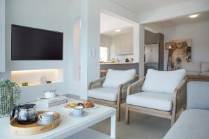 a living room with two chairs and a table at Villa Consta with Tennis, Saltwater Pool & Sea Views by KB Hospitality in Dhaskalión