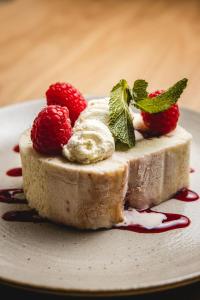 a piece of cheesecake with strawberries on a plate at Bertram's in Warkworth