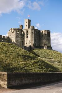 a castle on top of a grassy hill at Bertram's in Warkworth