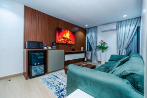 a living room with a blue couch and a fireplace at Aurum on Missouri in Abuja
