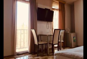 a hotel room with a table and chairs and a television at Hotel New Royal in Tbilisi City +23 photos