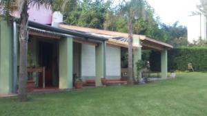 a house with a porch and a grass yard at CARELHUE-1 Zarate in Zárate